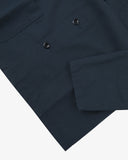 Closer view bottom-right section of blueberry, buttoned ripstop overshirt from Uskees. Focus on cuff, pockets and corozo buttons.