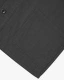 View of the mid-section and sleeve of the 3001 Uskees button-down drill overshirt in charcoal-grey with focus on hem and hip pocket.
