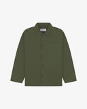 Front flat shot of coriander-green, buttoned organic cotton overshirt. Clear view of chest and hip pockets, corozo buttons and Uskees branding label.