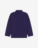 Back view of deep indigo, buttoned organic cotton overshirt with view of reinforced elbow area and boxy silhouette.