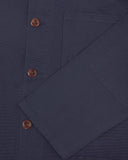 Closer view of mid section of midnight blue, buttoned organic cotton overshirt from Uskees. Focus on cuff, pockets and corozo buttons.