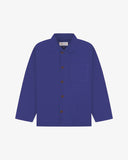 Front flat shot of ultra blue, buttoned organic cotton overshirt. Clear view of chest and hip pockets, corozo buttons and Uskees branding label.