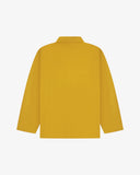 Back view of yellow, buttoned organic cotton overshirt with view of reinforced elbow area and boxy silhouette.