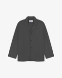 Charcoal-grey buttoned organic cotton-drill blazer from Uskees with clear view of three patch pockets and Uskees branding label.