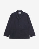 Full front view of deep blue buttoned organic cotton-twill blazer with clear view of three patch pockets and Uskees branding label.