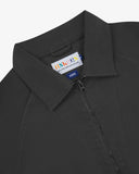 Close up view of Uskees charcoal-grey drill field jacket with focus on the collar, zipper, hanging hook and branding label.