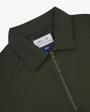 Close up view of Uskees vine green drill field jacket with focus on the collar, zipper, hanging hook and branding label.