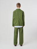 Back view of male model wearing the Uskees 3047 Docklands coriander green blazer with view of back vent.