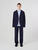 Full-length front view of male model wearing the Uskees 3047 Docklands midnight blue blazer unbuttoned, paired with matching Uskees pants.