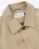 Uskees beige men's car coat with focus on collar detail showing the Uskees brand label, hanging loop and corozo buttons.