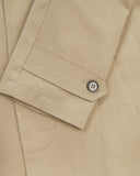 Uskees beige car coat sleeve with focus on cuff and button.