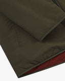 Close up view of Uskees army green Evo liner jacket with focus on the left welt pocket, cuff and hemline.