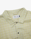 Close up flat shot of Uskees pastel yellow check coach jacket for men with focus on collar, contrast inner yoke, Uskees brand label and popper buttons.