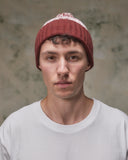 Front view of model wearing the dusty pink Fair Isle pattern hat from Uskees, clearly showing the ribbing of the adjustable cuff.