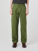 Close-up front view modelling 5021 Uskees men's organic twill coriander-green painter pants highlighting relaxed, flattering fit.