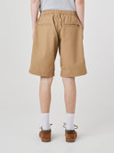 Bottom-half back view of male model wearing khaki 5024 men's ripstop utility shorts with clear view of jetted back pockets and small Uskees tab label.