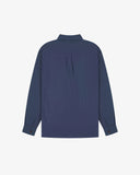 Flat back view of mid blue organic chambray Oxford shirt from Uskees with view of open pleat and longer rear hem so it can be tucked in more easily.