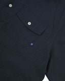 Angled mid-view of #6007 buttoned organic cotton dark blue short sleeve shirt with focus on button down flap chest pocket and Uskees branding tag.
