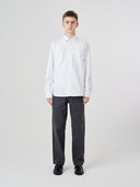 Man wearing Uskees white men's Oxford shirt, paired with Uskees dark grey pants.