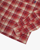 Close up view of an Uskees red clay check long sleeved flannel shirt for men showing the cuff, sleeve and button detail.