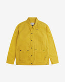 Flat shot front of Uskees wax storm jacket in British yellow showing the boxy silhouette and all the features which make this an effective weather-repellent garment. 