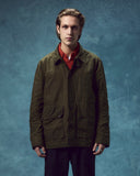 Front view of man wearing the Uskees wax storm jacket in dark 'Pennine' green.