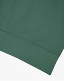 Closer view view of the discreet brand logo on ribbed hem of the Uskees green organic heavyweight cotton 7005 jersey sweatshirt.