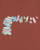 Close-up of brown men's t-shirt with focus on deconstructed geometric Uskees logo in pastel colours.