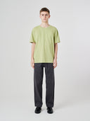 Full-length view of model wearing 7006 green-yellow organic cotton t-shirt, demonstrating loose fit.