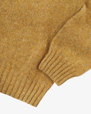 Closer view of Alderney crew neck jumper in Scottish new wool from Uskees. Focus on cuff, hem, multicoloured speckles and wool texture.